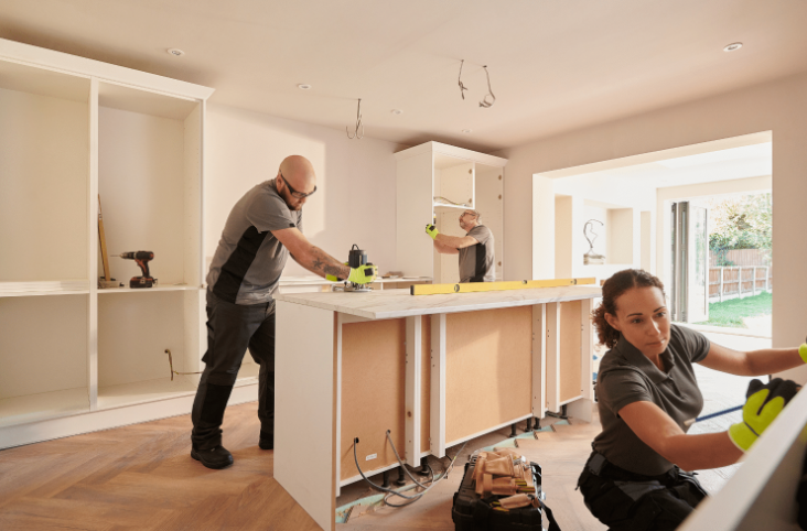 Kitchen remodeling team installing cabinets and island